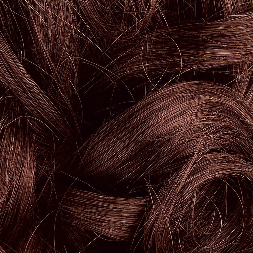 Primo piano di capelli lunghi e mossi, castano caldo con riflessi ramati.