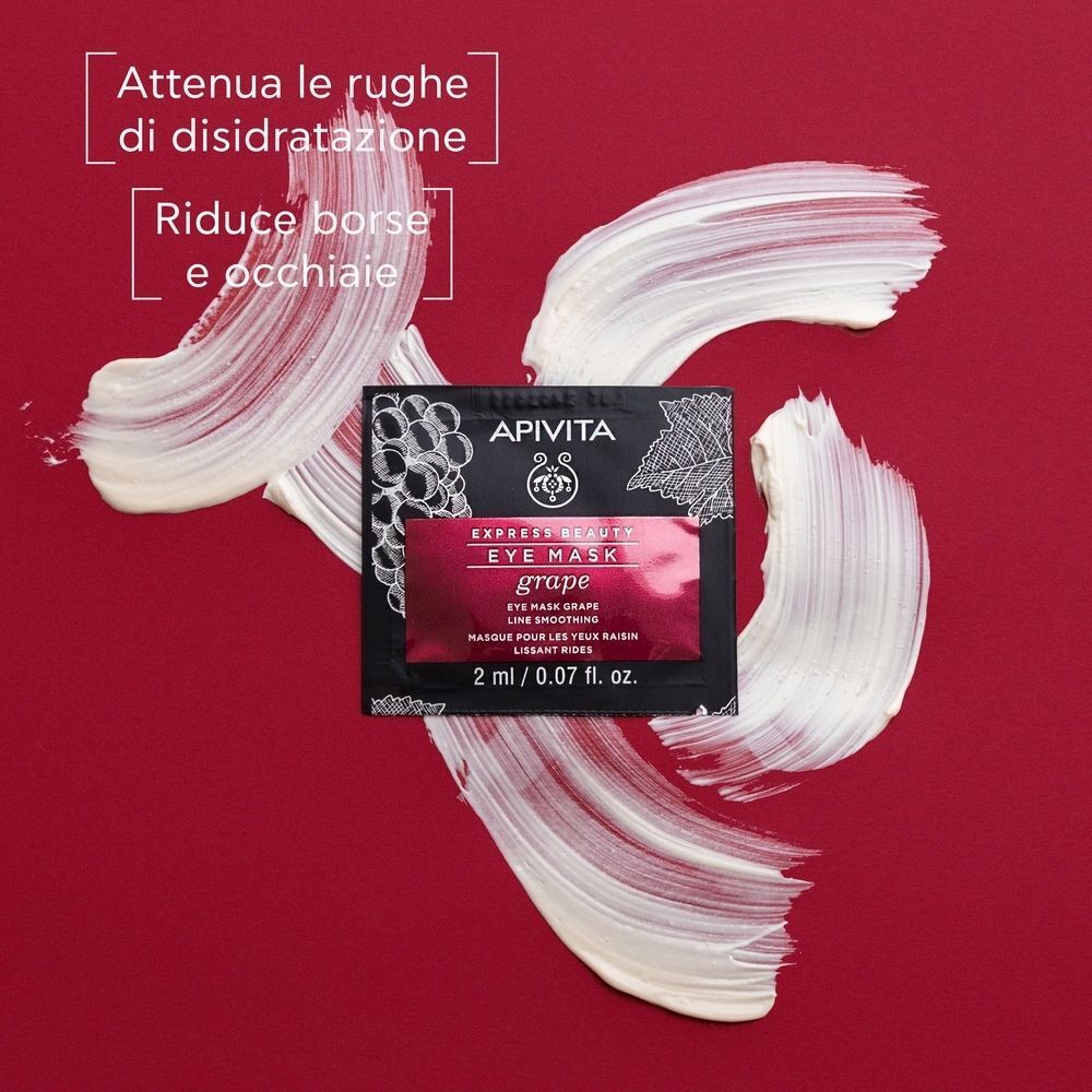 Maschera contorno occhi APIVITA EXPRESS BEAUTY uva con tocchi di crema su sfondo rosso.