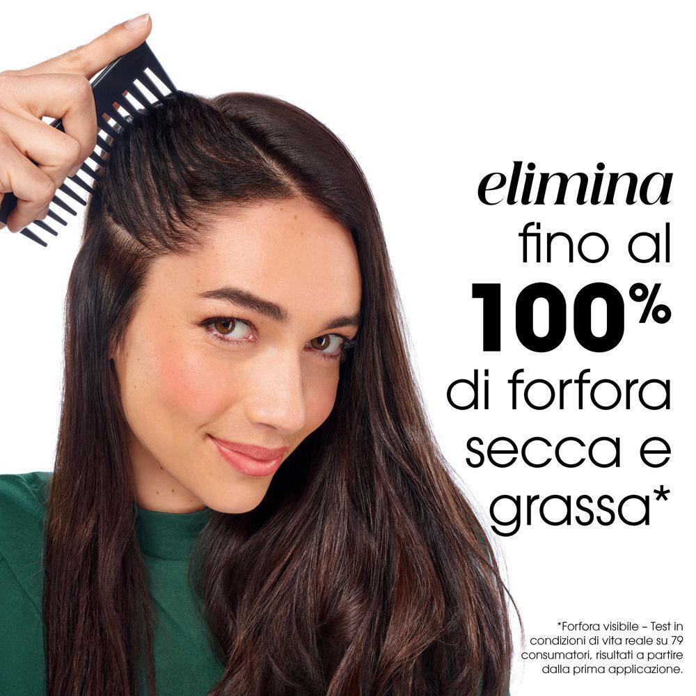 Donna con capelli scuri che si pettina il cuoio capelluto.