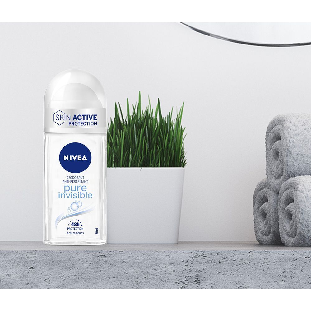 Deodorante roll-on Nivea Pure Invisible su uno scaffale vicino a una pianta e asciugamani.