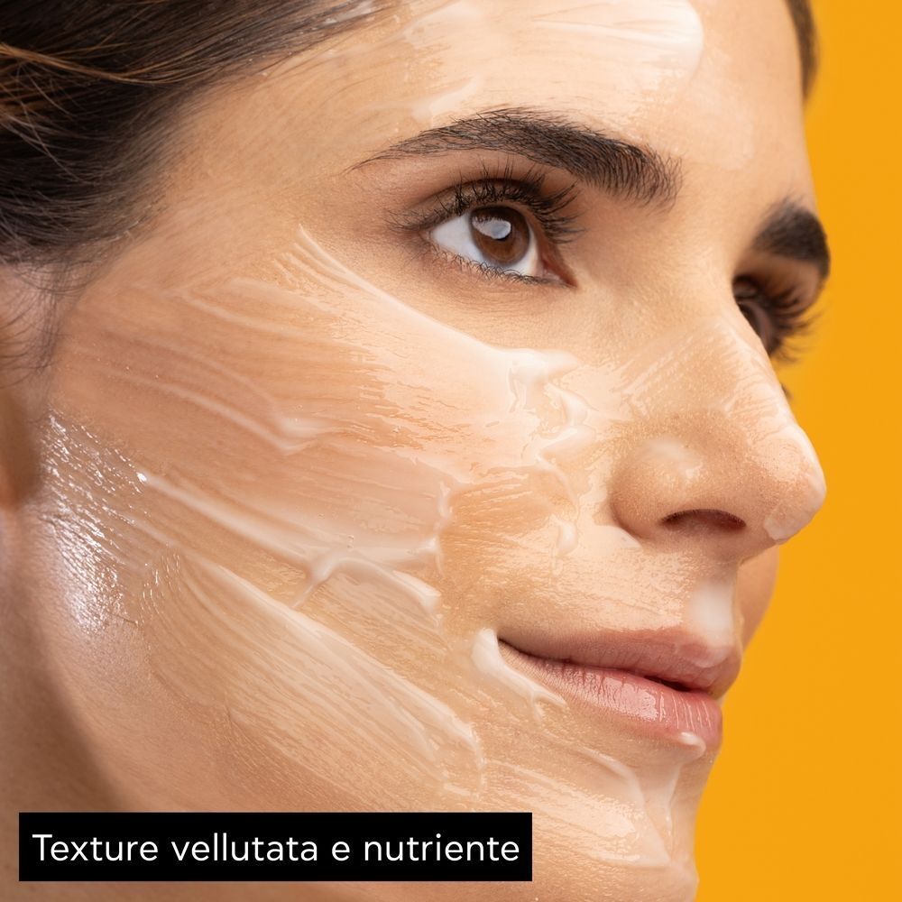 Primo piano di una donna che indossa una maschera facciale cremosa.