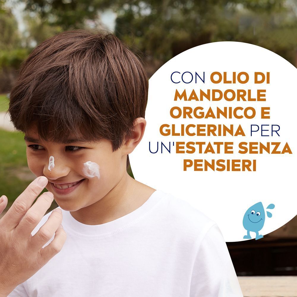 Un bambino riceve lo spray solare Nivea Sun sul naso e sulle guance.