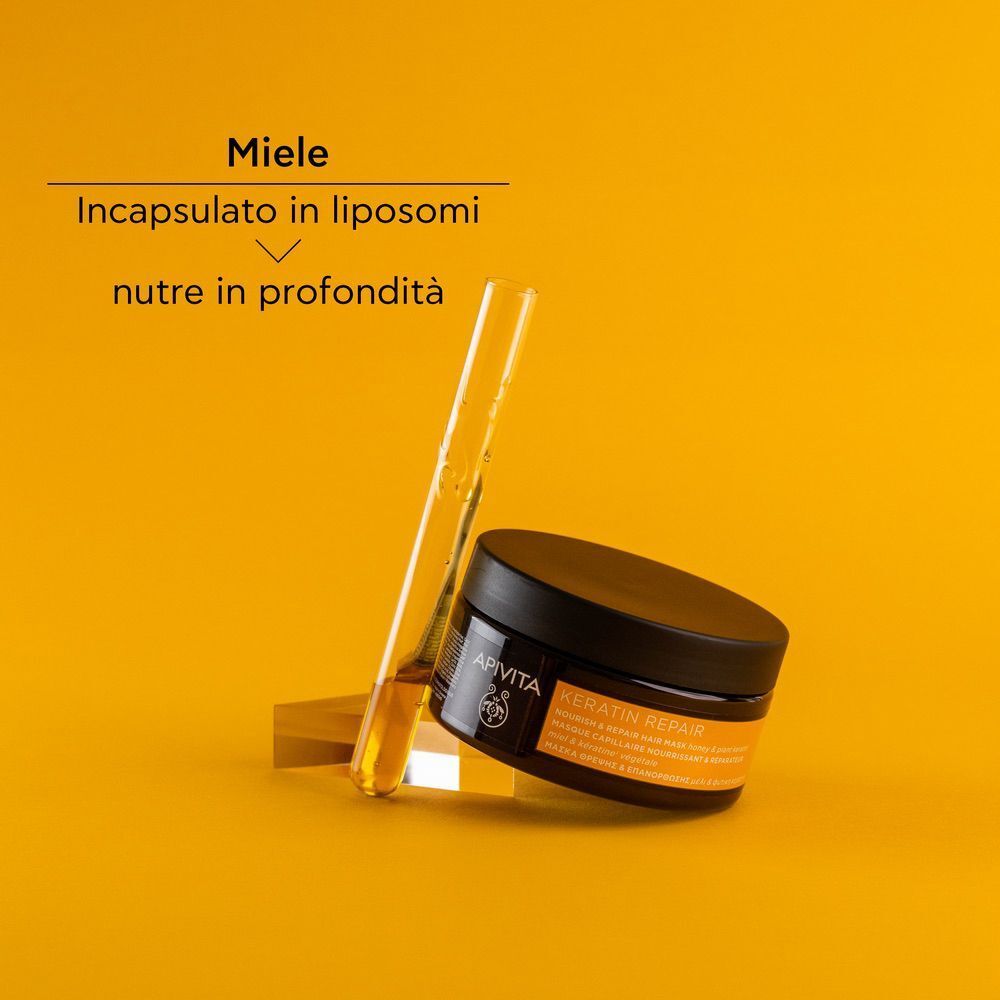 Maschera capelli APIVITA Keratin Repair accanto a una provetta con miele.