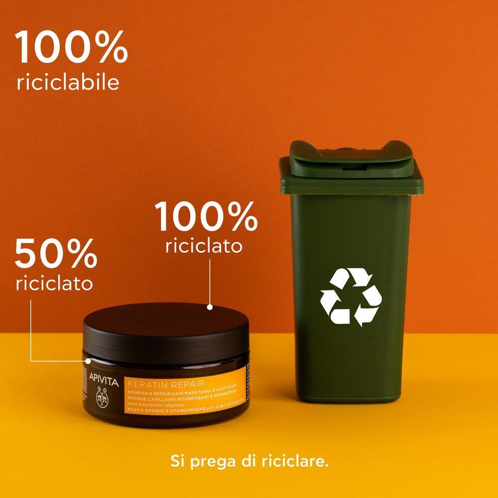Maschera capelli APIVITA Keratin Repair accanto a un bidone di riciclaggio, 100% riciclabile.