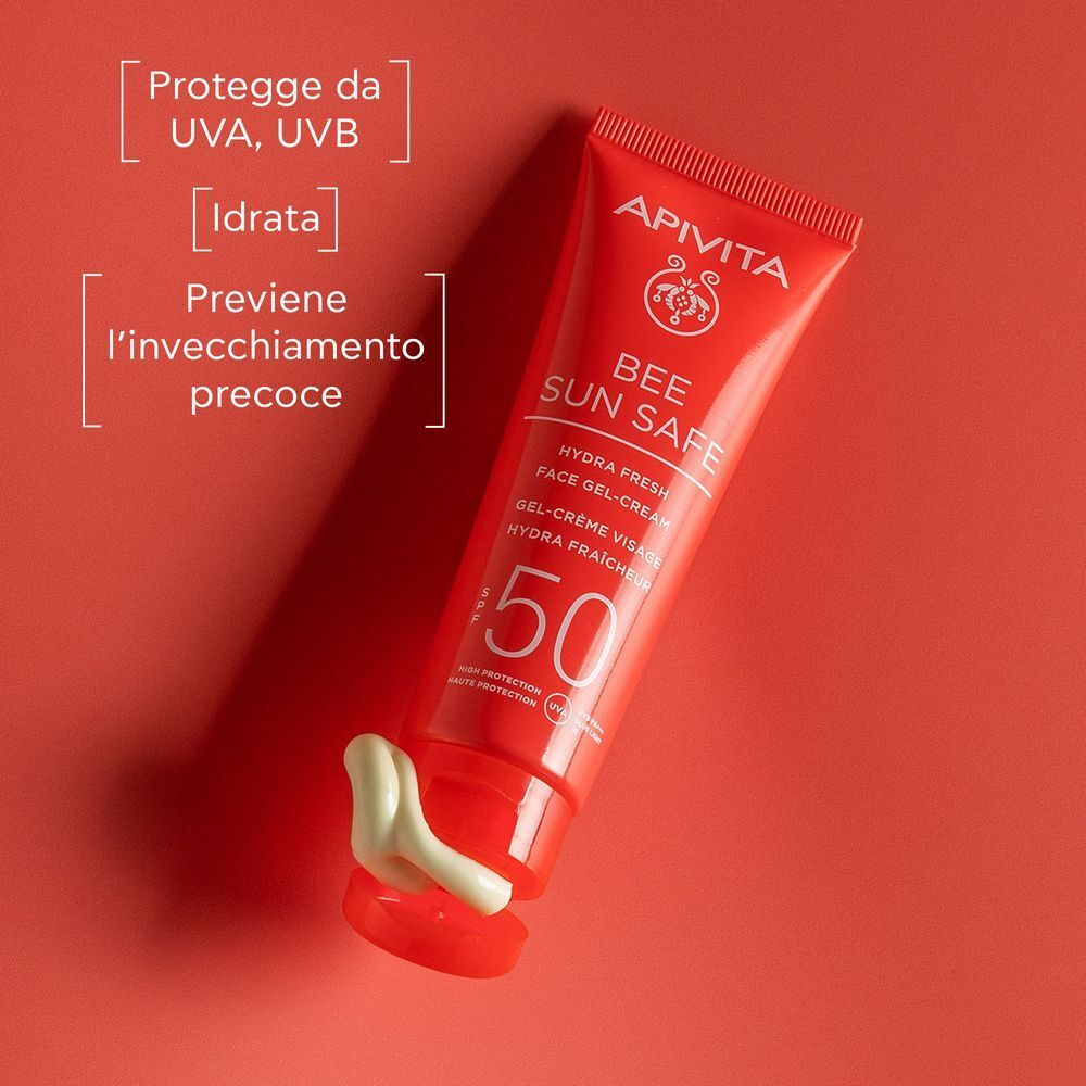Tubo rosso crema solare SPF 50, aperto con crema bianca. Protegge da UVA/UVB, idrata.