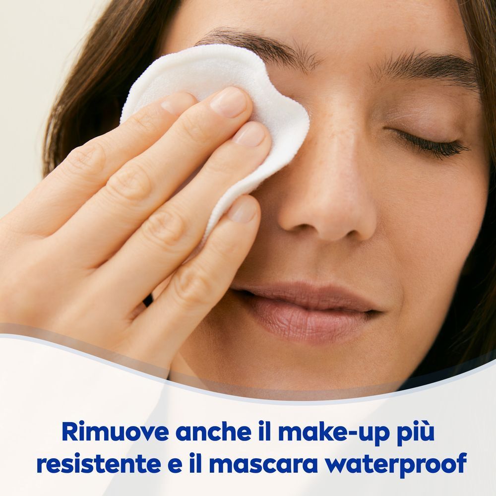 Donna che rimuove il trucco con un dischetto di cotone.