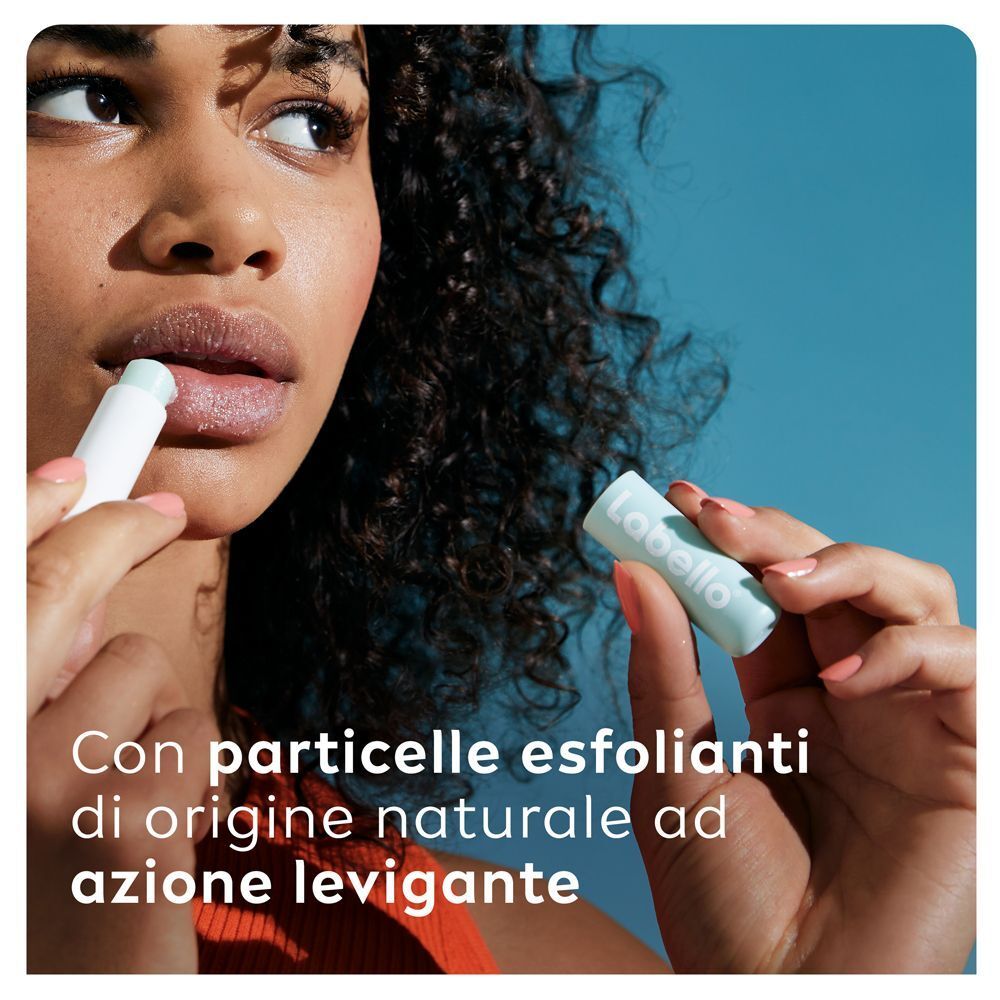 Una donna applica il balsamo Labello Caring Scrub con particelle esfolianti naturali.