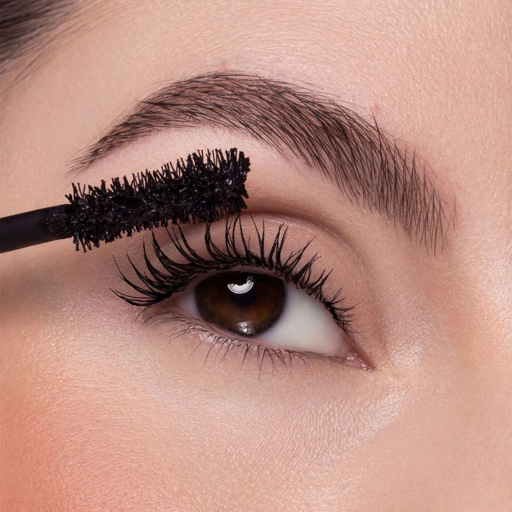 Primo piano di una donna che applica il mascara sulle ciglia.