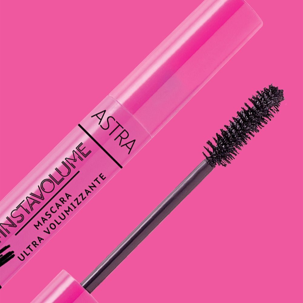 Mascara Astra Ultra-Volumizzante rosa con applicatore su sfondo rosa.