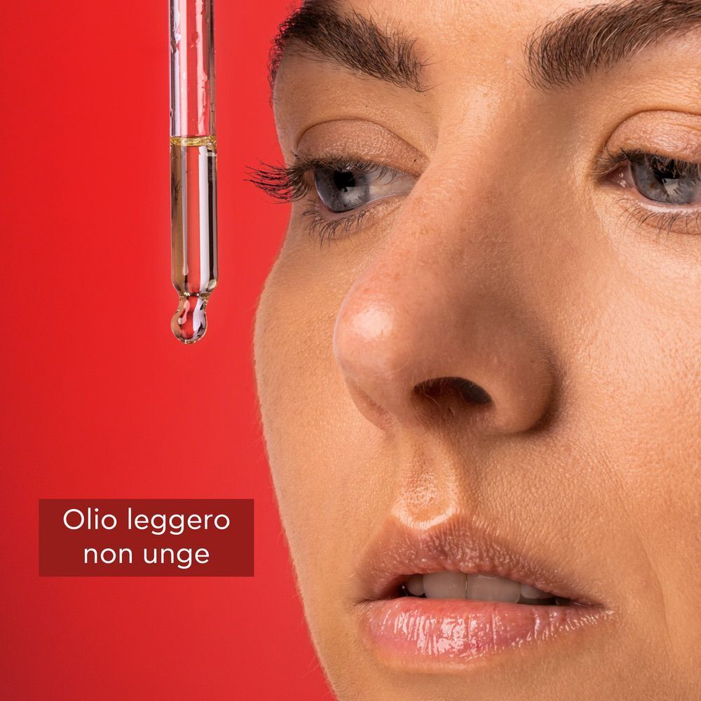 Primo piano di un viso con una goccia di Olio Viso Apivita Beevine Elixir che cade da una pipetta.
