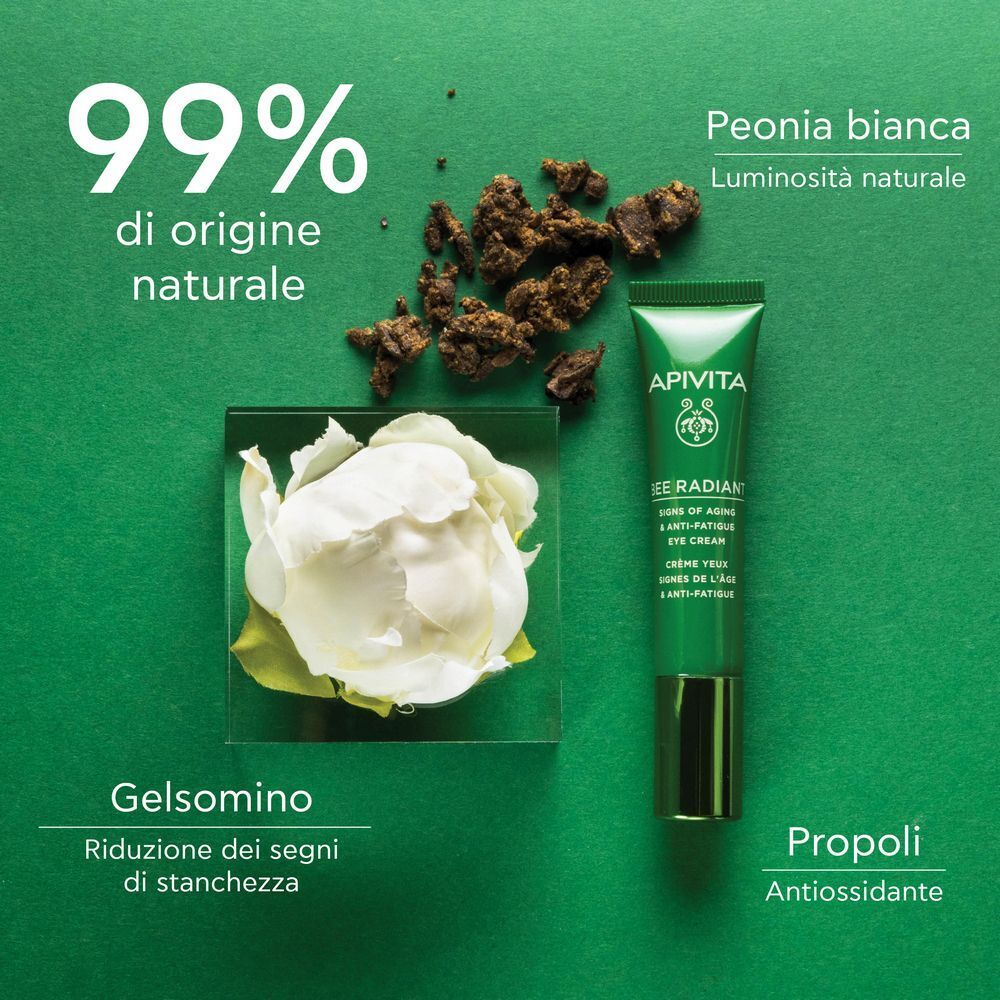 Crema contorno occhi APIVITA Bee Radiant accanto a fiori bianchi e pezzi di propoli.