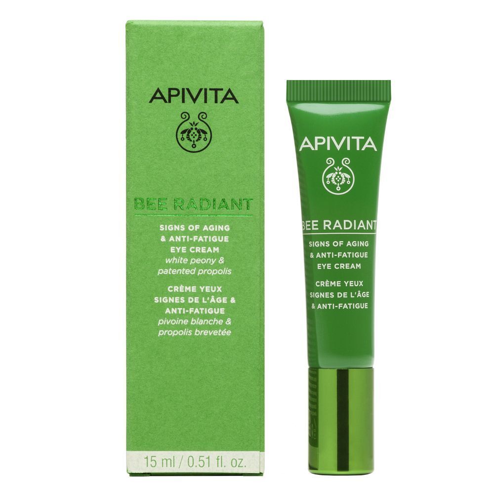 Tubetto di crema contorno occhi APIVITA Bee Radiant con crema applicata. Attrezzatura da laboratorio sullo sfondo.