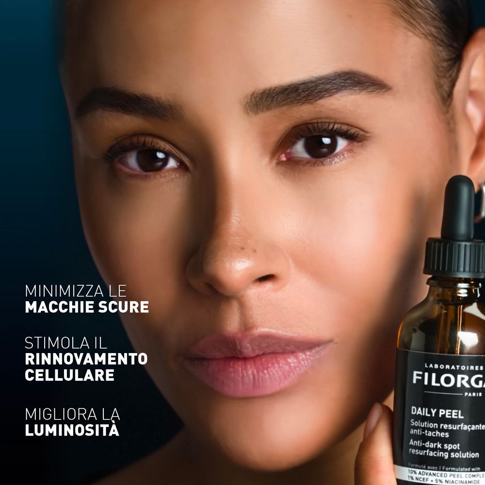 Donna con flacone Filorga Daily Peel. Testo: "Minimizza le macchie scure, stimola il rinnovamento cellulare, migliora la luminosità".