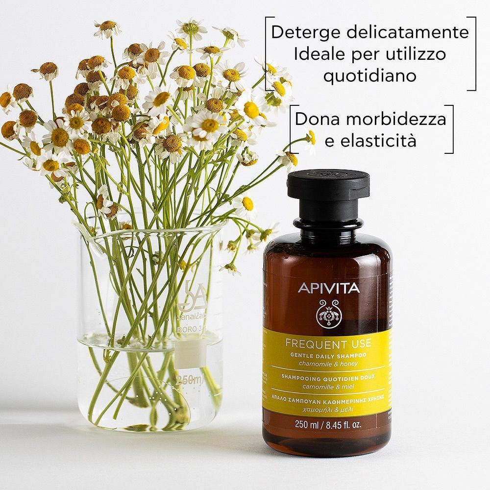Shampoo APIVITA Frequent Use accanto a camomilla e un becher.
