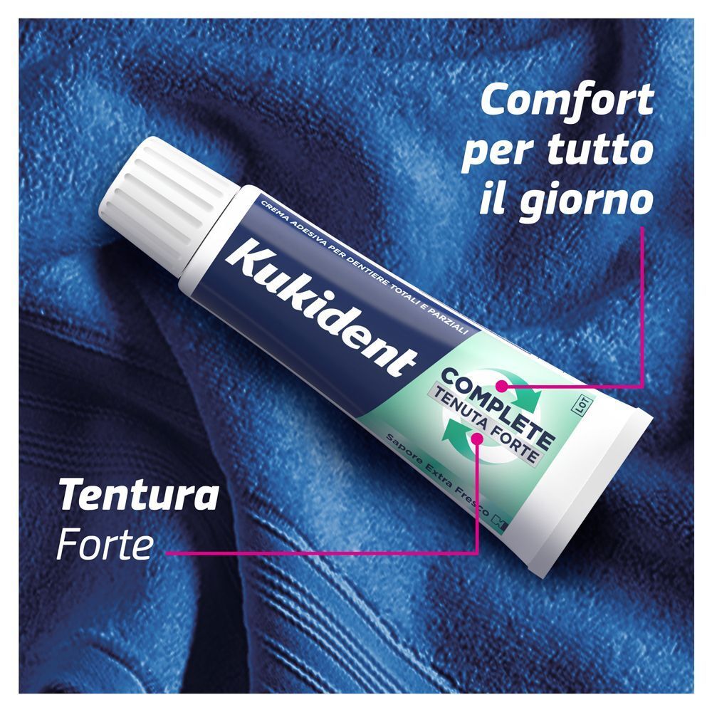 Kukident Complete crema adesiva su asciugamano blu. Tenuta forte, comfort.