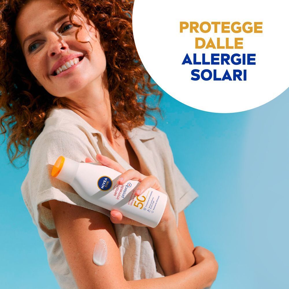 Donna con capelli ricci tiene un flacone Nivea Sun Sensitive Immediate Protect SPF 50+. Testo: Protegge dalle allergie solari.