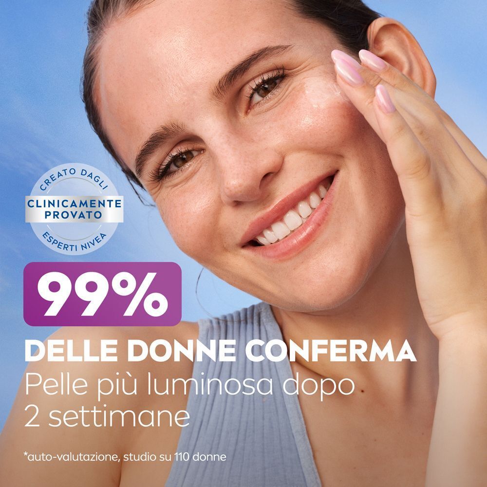 Donna con pelle luminosa, tiene in mano un flacone di siero Nivea Luminous630 Skin Glow.