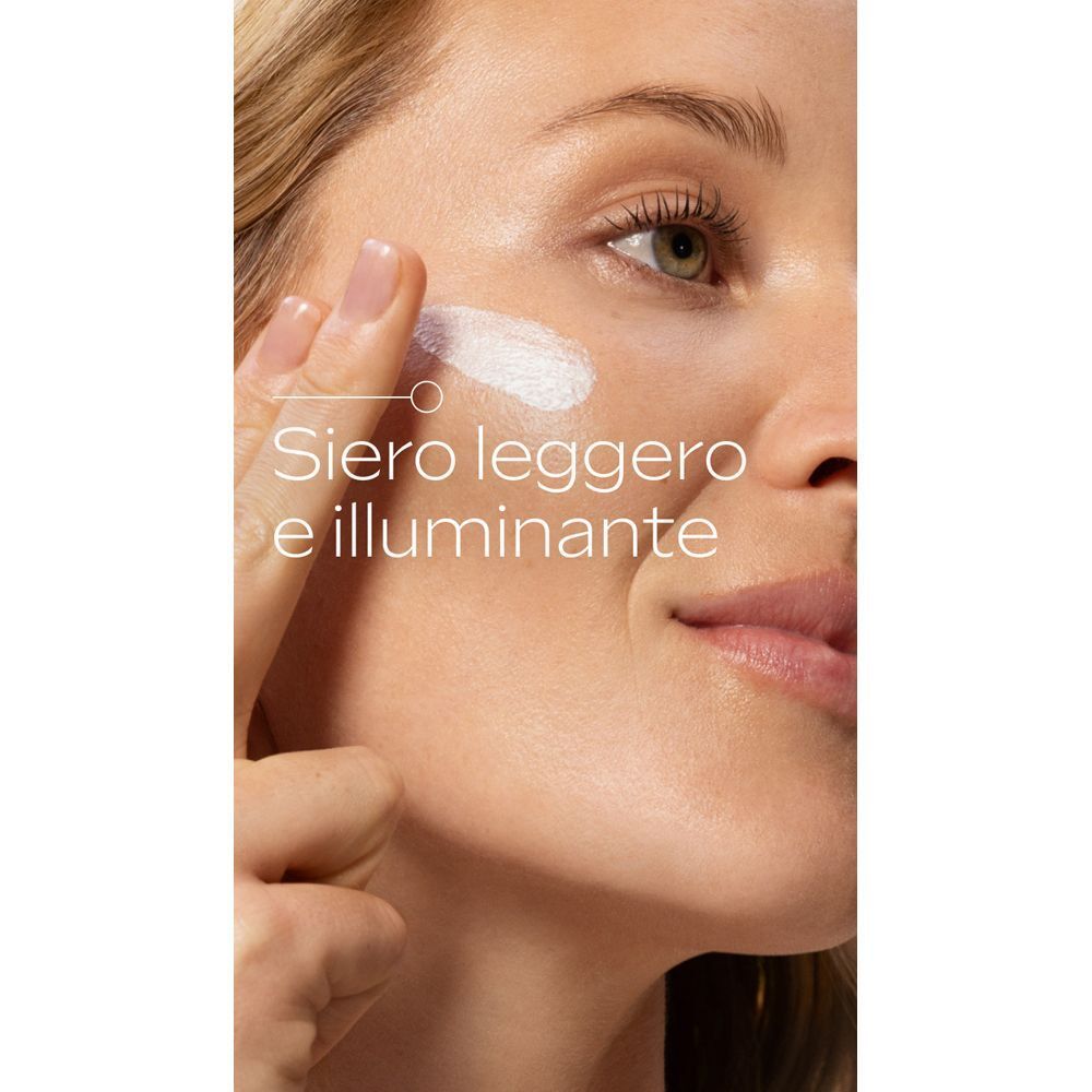 Una persona applica una crema siero leggera e illuminante sulla guancia.