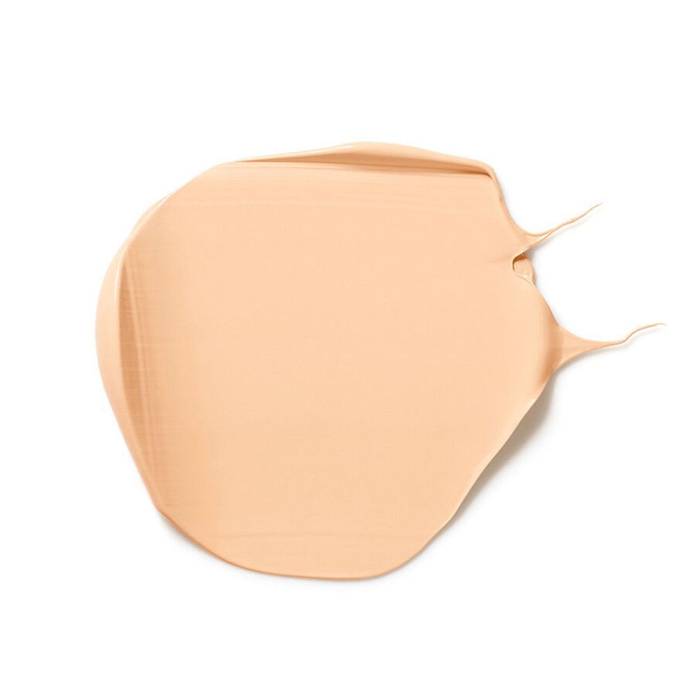Una macchia di fondotinta beige chiaro su sfondo bianco.