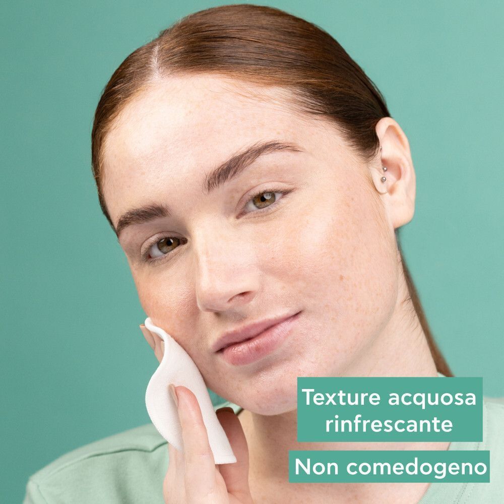 Donna applica lozione Apivita Just Bee Clear con dischetto di cotone. Testo: 'Texture acquosa rinfrescante', 'Non comedogeno'.