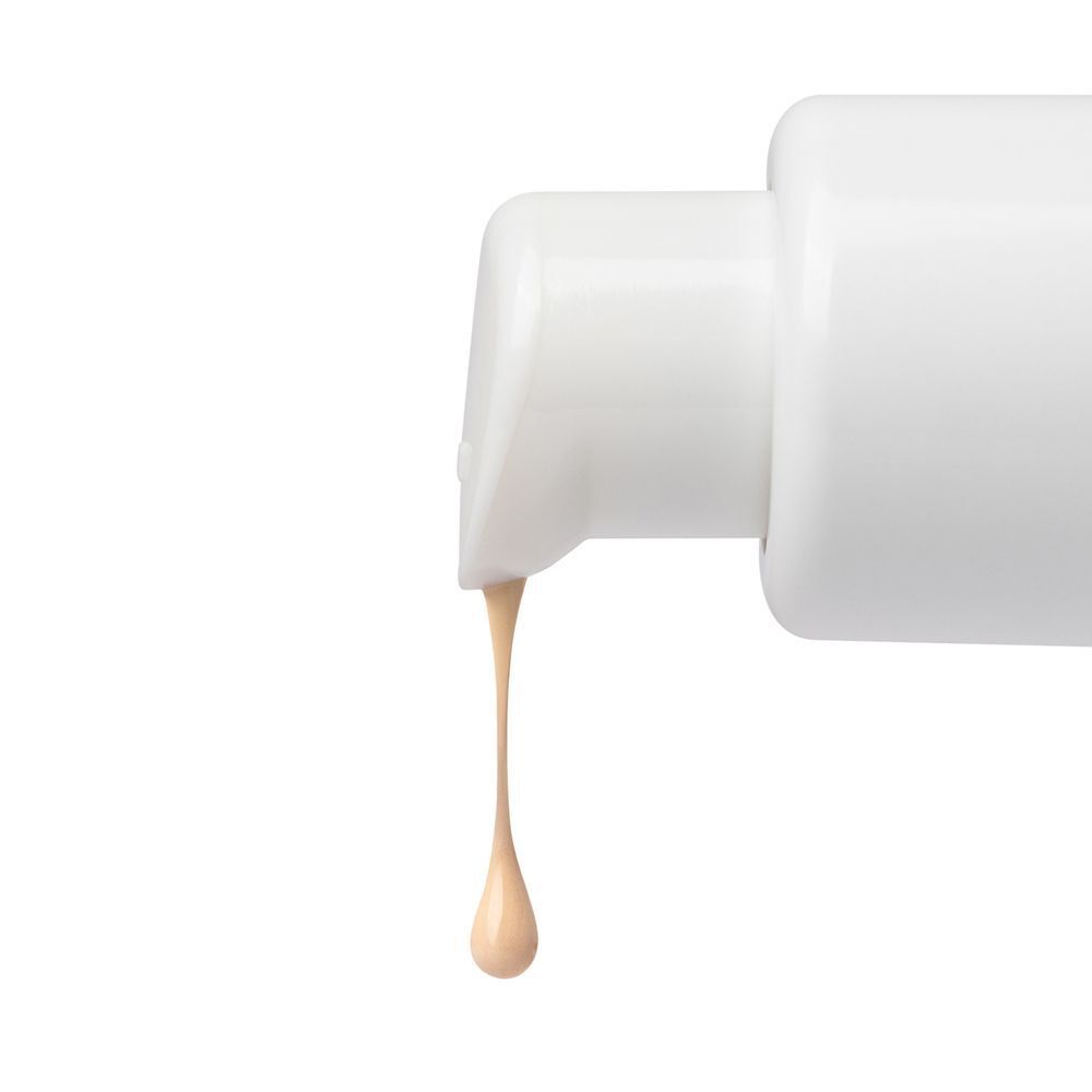 Primo piano dell'erogatore di ASTRA Make-Up Fluid Foundation Serum, con una goccia di prodotto.