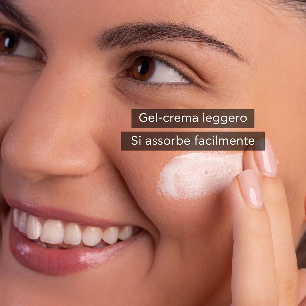 Una donna applica la crema-gel viso APIVITA Bee Sun Safe SPF 30 sulla sua guancia.