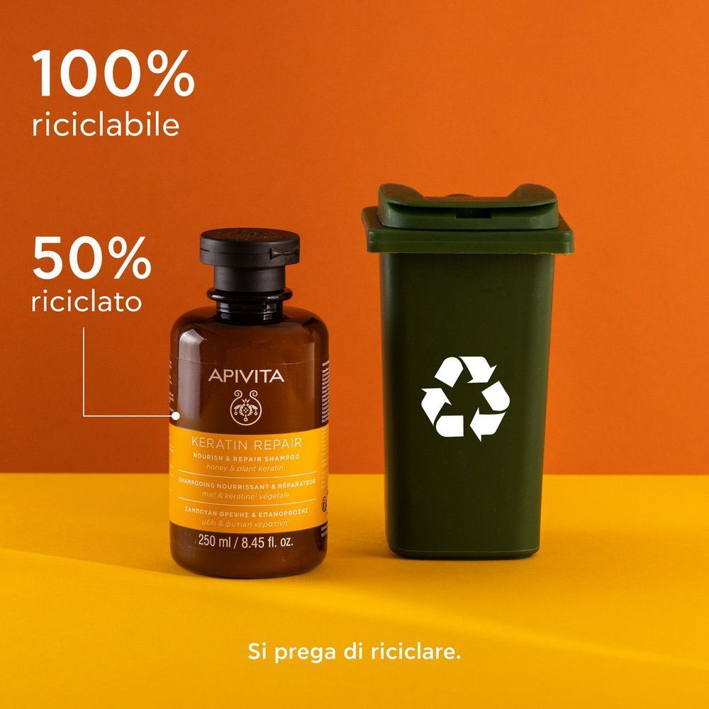 Shampoo riparatore alla cheratina APIVITA accanto a un bidone della spazzatura verde con simbolo di riciclo.