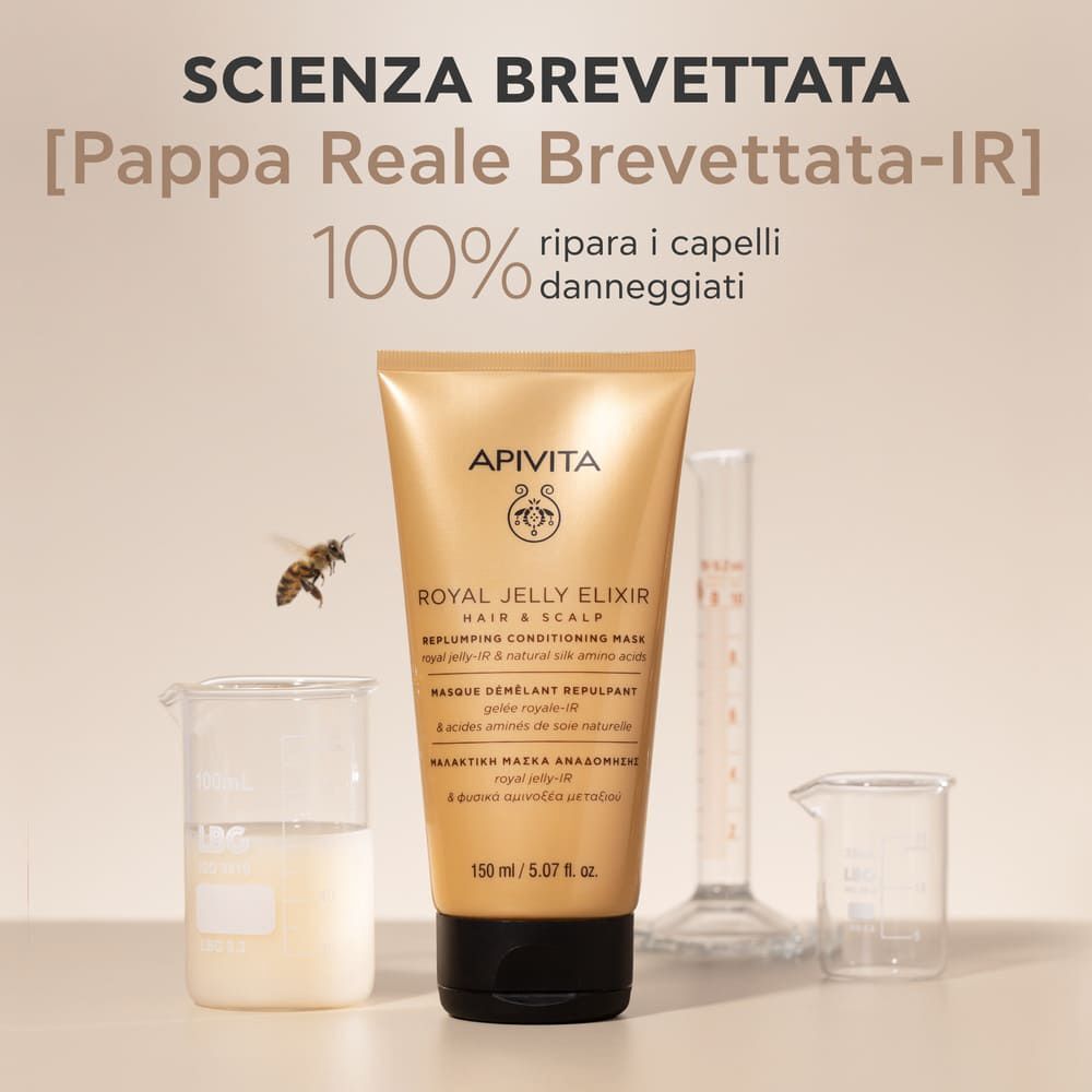 Tubo Apivita Royal Jelly Elixir Maschera Balsamo Rimpolpante tra becher e cilindro graduato. Un'ape vola nelle vicinanze.