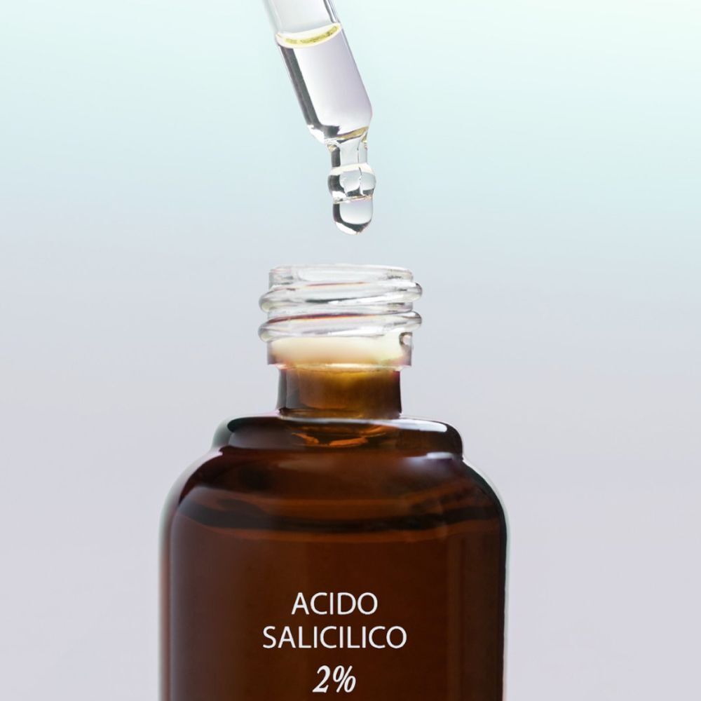 Una pipetta rilascia una goccia in un flacone di Complesso Peeling Acido Salicilico 2%.