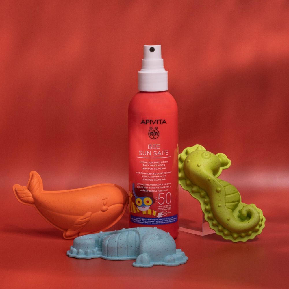 Flacone spray rosso di protezione solare con giochi da spiaggia: balena, cavalluccio marino, delfino.