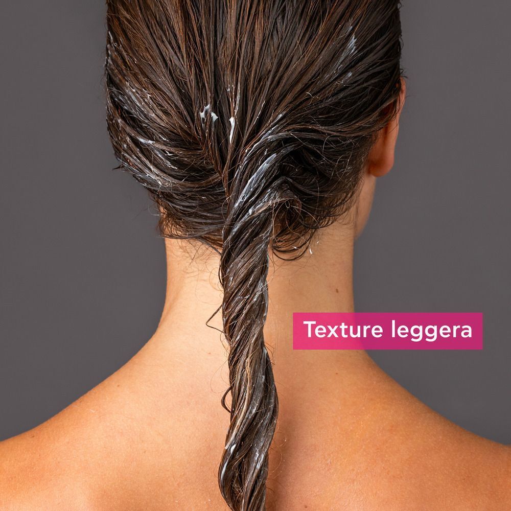 Ciocca di capelli bagnata con la texture leggera del balsamo tonificante APIVITA.