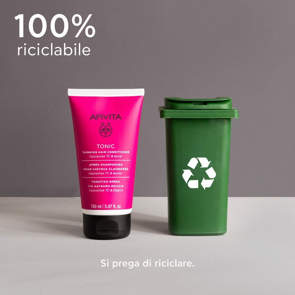 Balsamo tonificante APIVITA per capelli fini, 150 ml, accanto a un bidone di riciclaggio verde.