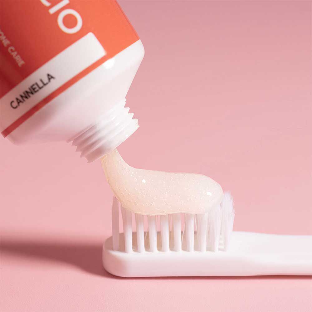 Dentifricio erogato da un tubetto su uno spazzolino.