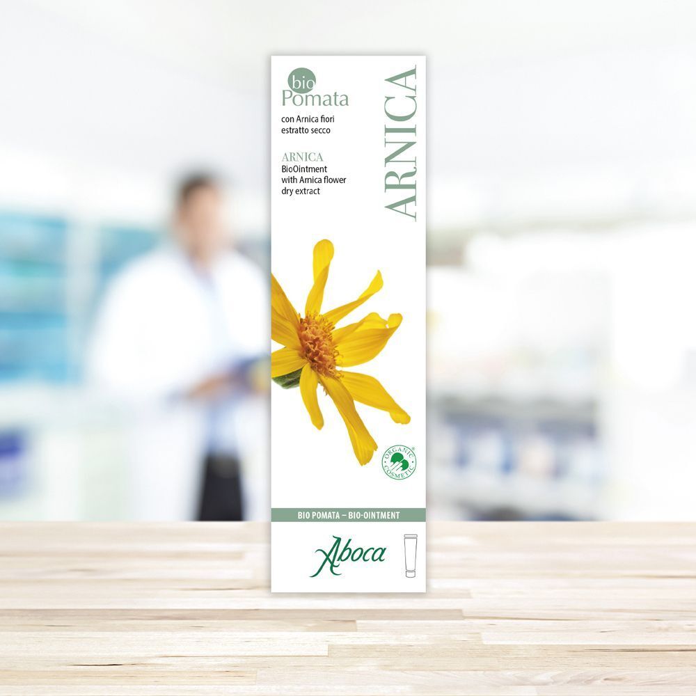 Una confezione di Arnica bioPomata con fiore giallo e logo Aboca.