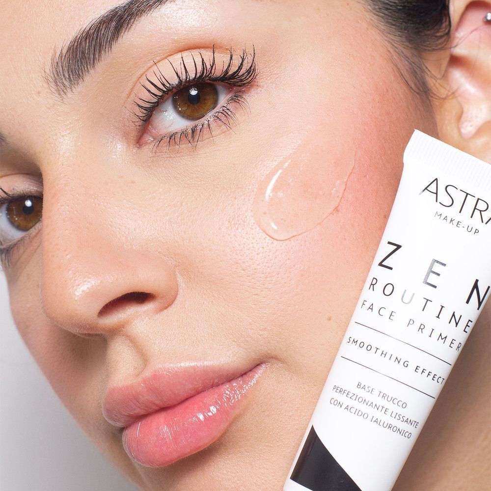 Viso di donna con texture di primer applicata e un tubetto ASTRA Make-Up Zen Routine Face Primer.