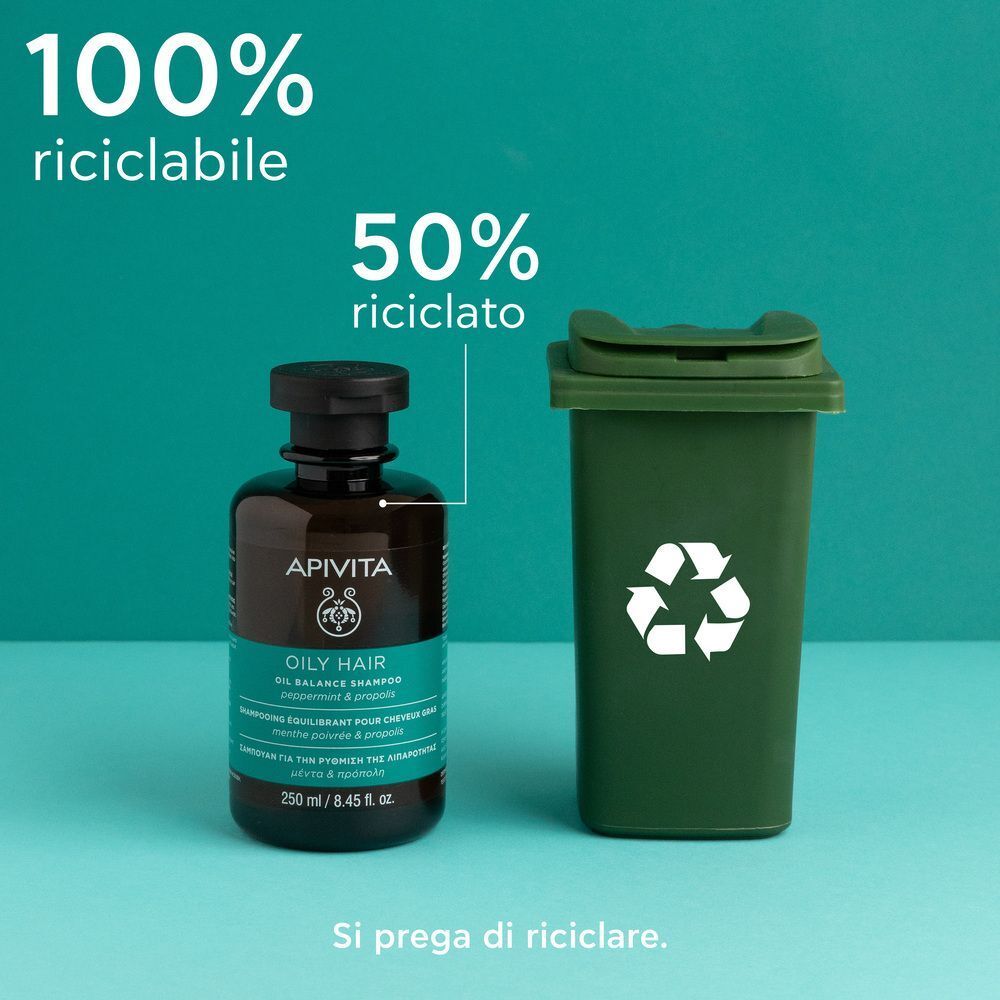 Shampoo APIVITA OILY HAIR Sebo-regolatore accanto a un bidone verde. 100% riciclabile, 50% riciclato.