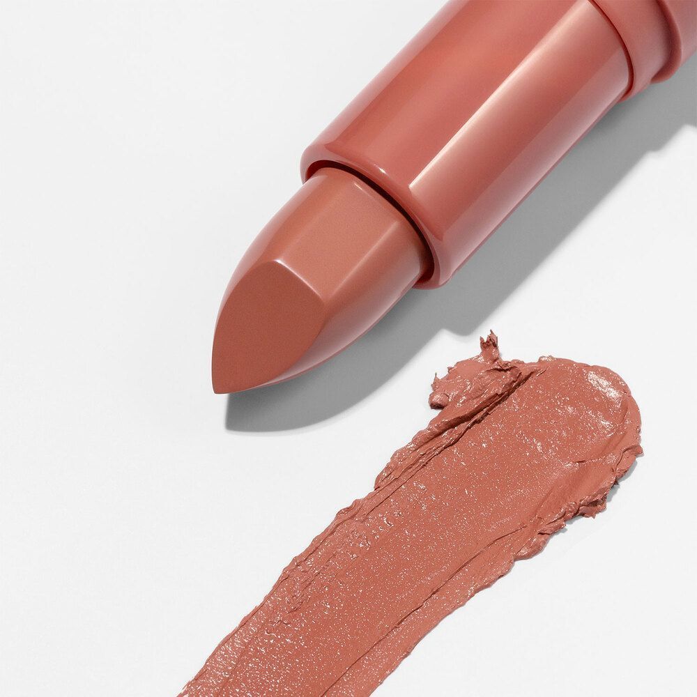 Un rossetto ASTRA Make-Up Lip Creamynal e una striscia di colore su sfondo bianco.