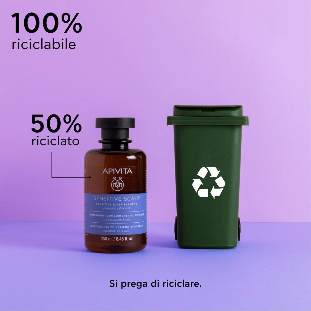 Shampoo APIVITA Cute Sensibile accanto a un bidone verde, 100% riciclabile.
