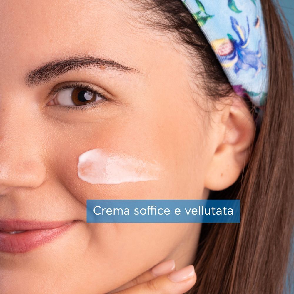 Primo piano di una donna con una texture cremosa sulla guancia.