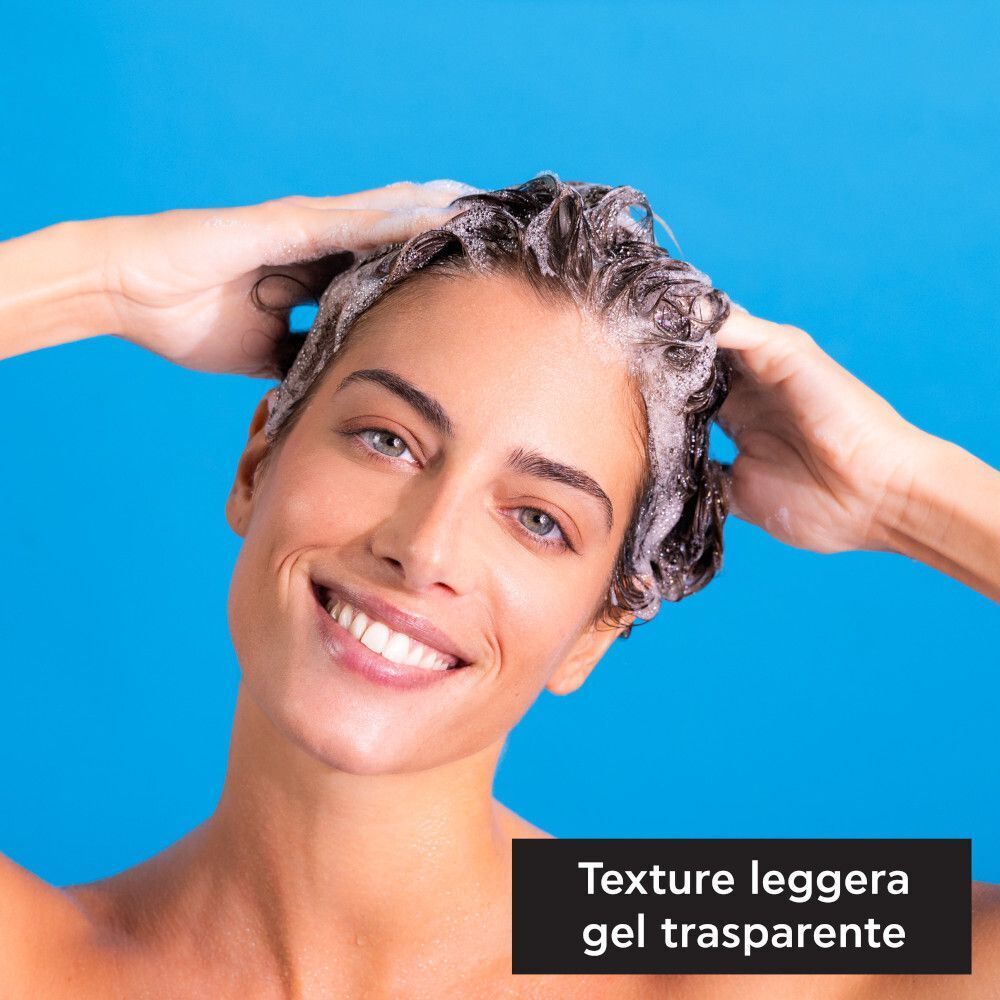 Donna che si lava i capelli con lo shampoo idratante APIVITA Hyaluronic Hydra.