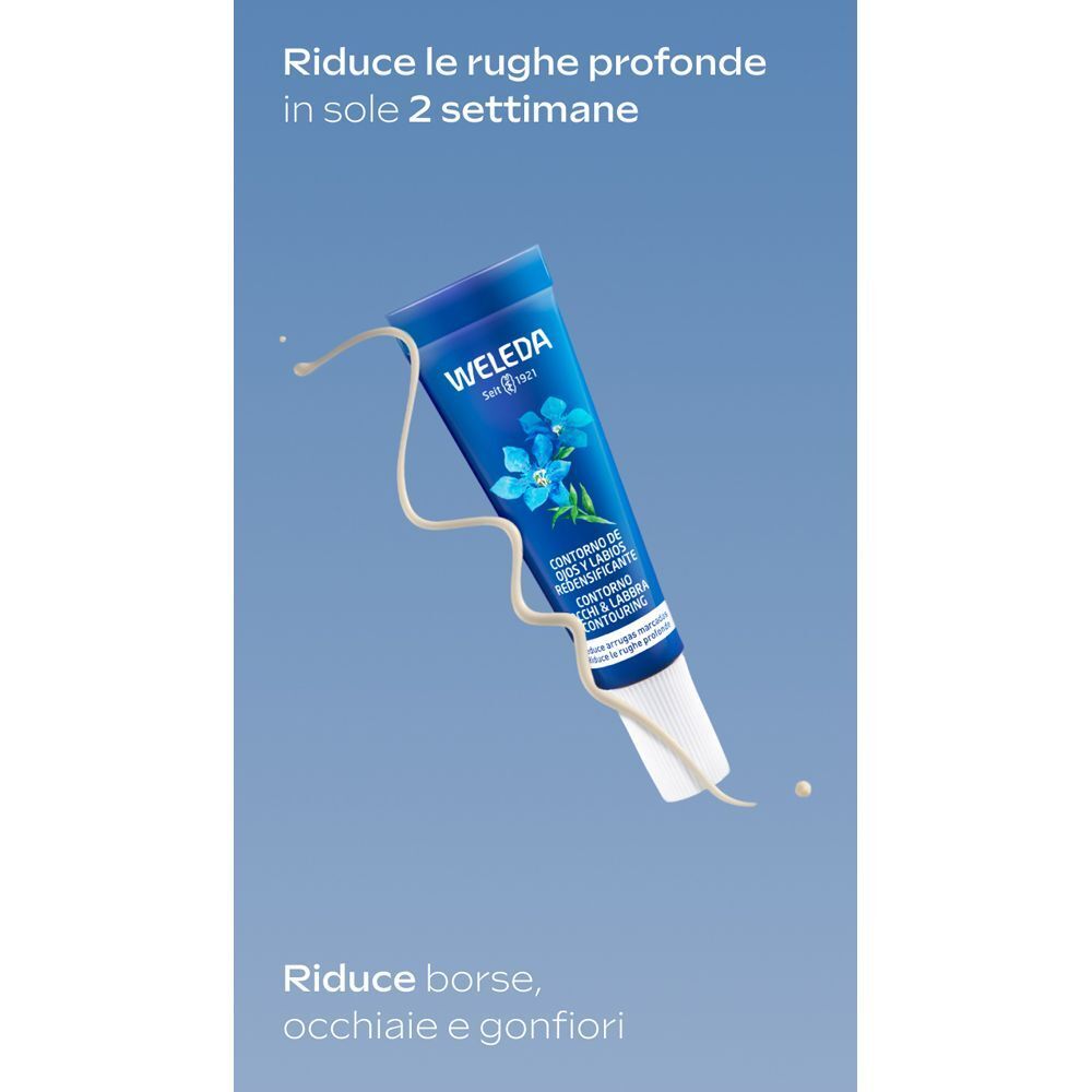 Tubetto di WELEDA Contorno Occhi e Labbra con fiori blu, circondato da schizzi di crema.