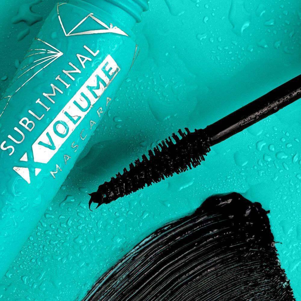 Tubetto di mascara turchese e il suo scovolino con mascara nero e gocce d'acqua.