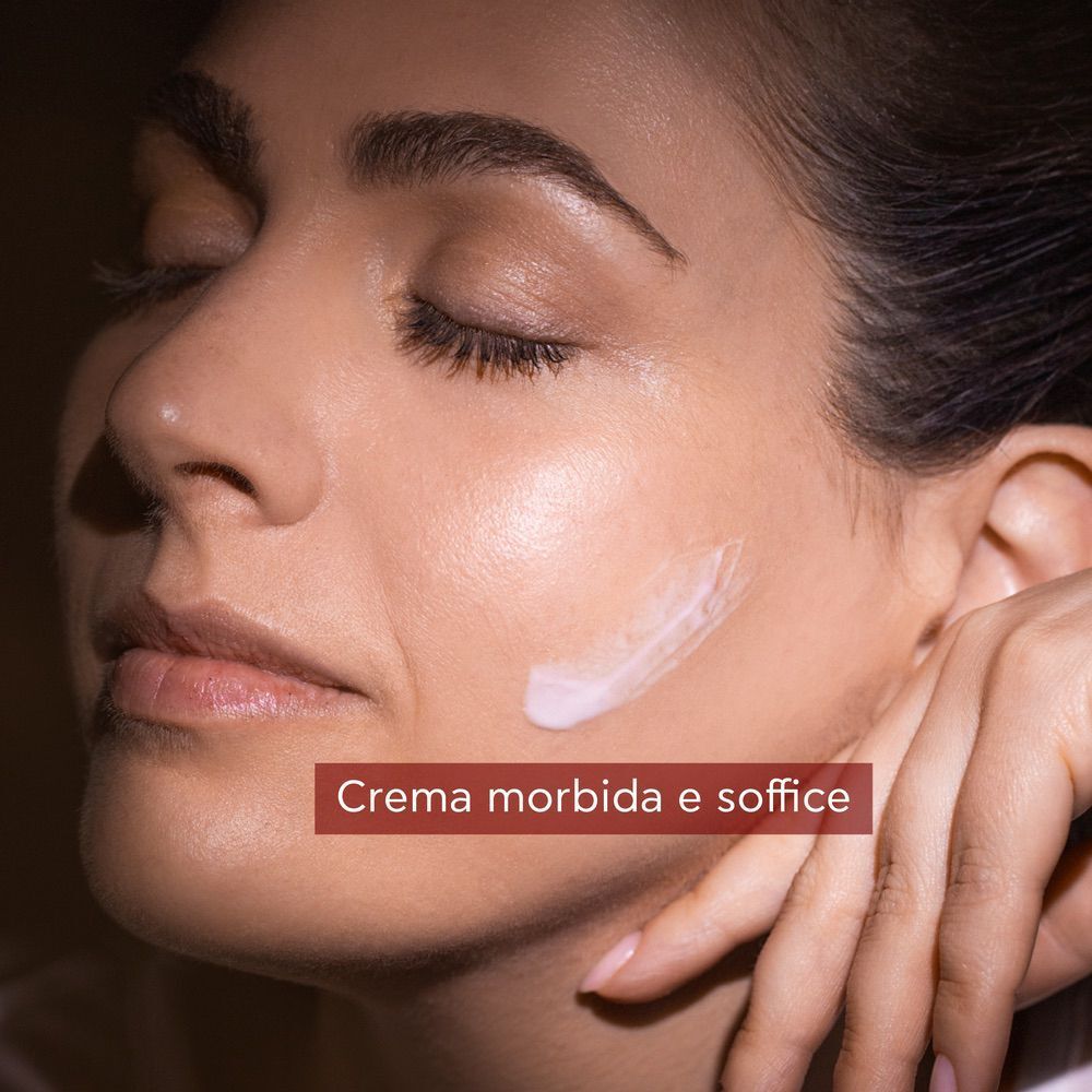 Crema sulla guancia di una donna con gli occhi chiusi.