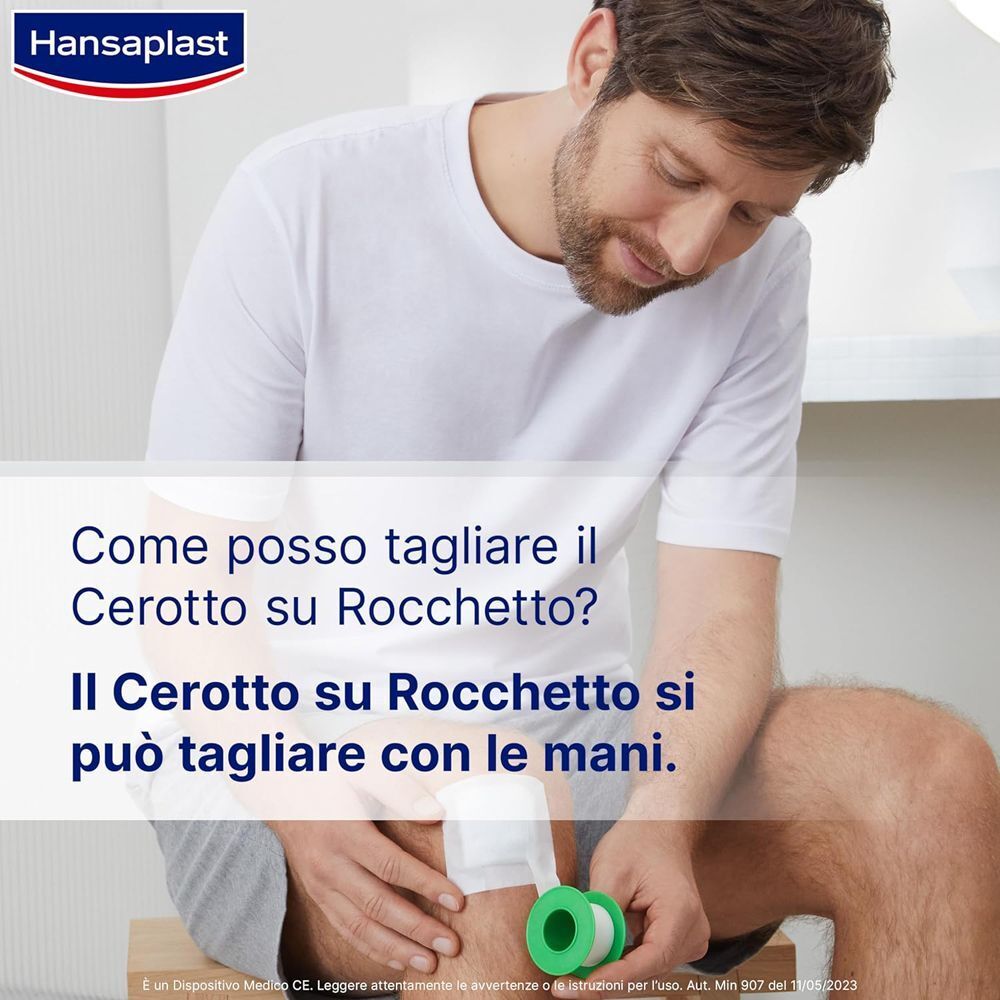 Uomo che taglia a mano il cerotto Hansaplast Sensitive per fissare una benda.