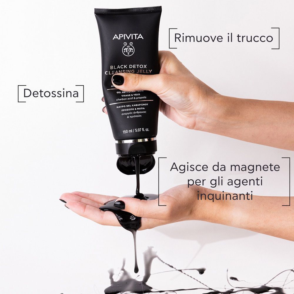 Mano che versa gel nero dal tubo APIVITA Black Detox Cleansing Jelly nel palmo.