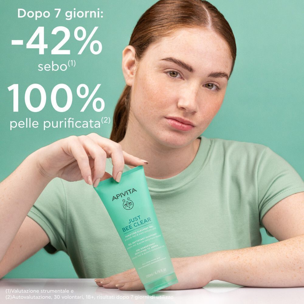 Una donna tiene un tubo di gel detergente Apivita Just Bee Clear; testo mostra risultati dopo 7 giorni.