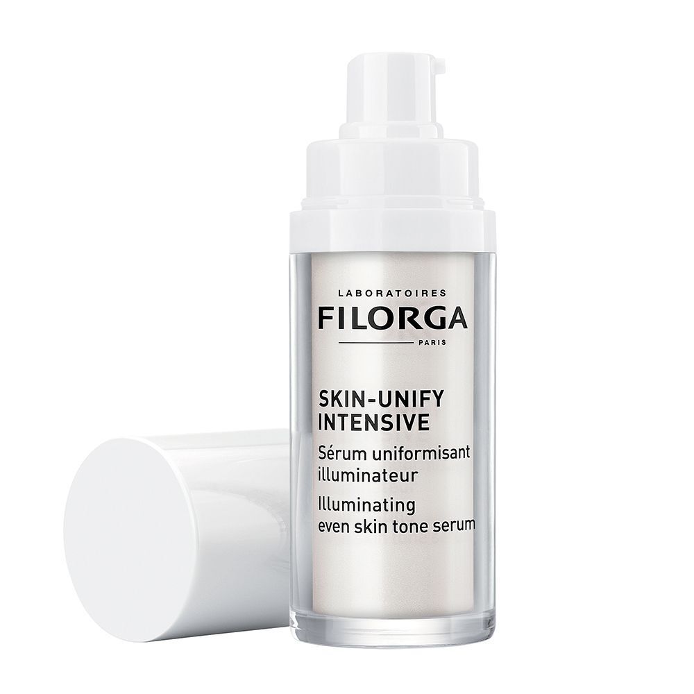 Un flacone di siero FILORGA Skin-Unify Intensive con dosatore a pompa, tappo bianco appoggiato accanto.