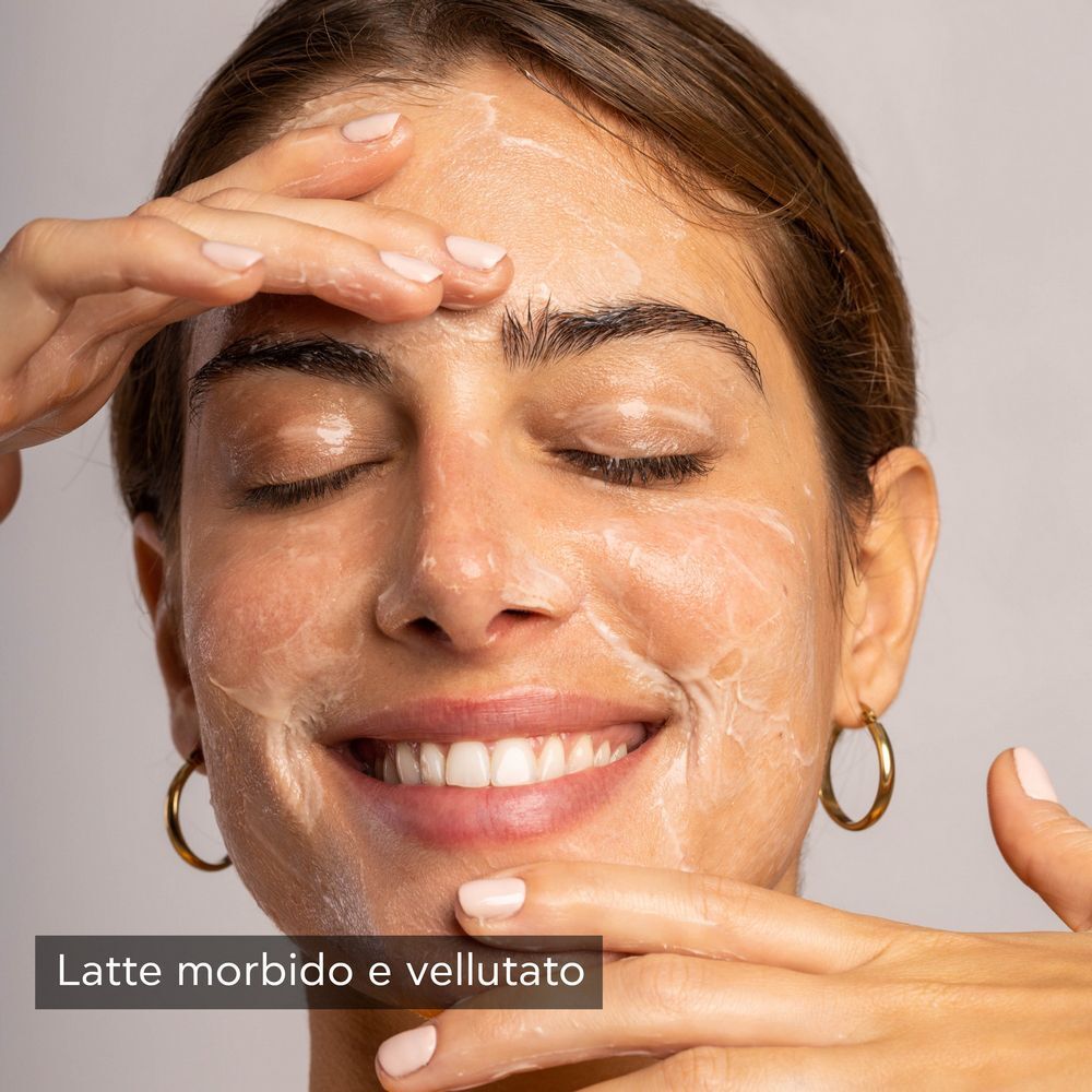 Donna con Latte Detergente APIVITA schiumoso sul viso.