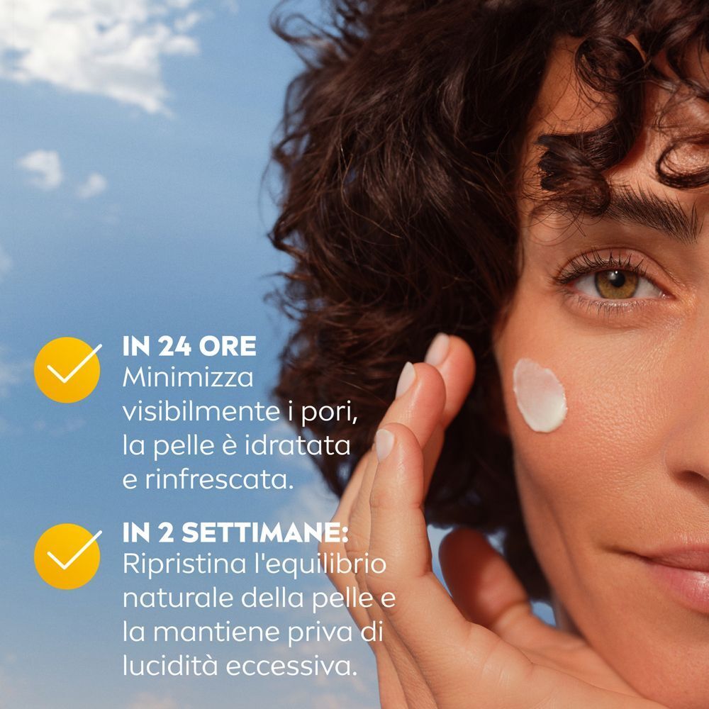 Donna applica crema giorno Nivea Q10. Minimizza i pori, idrata.