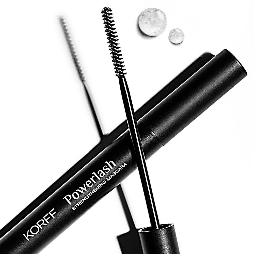 Un applicatore di mascara KORFF Powerlash accanto a un flacone nero.